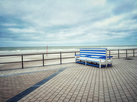 Blue-white striped bench at the seafront in Middelkerke, West- Flanders, Belgium.