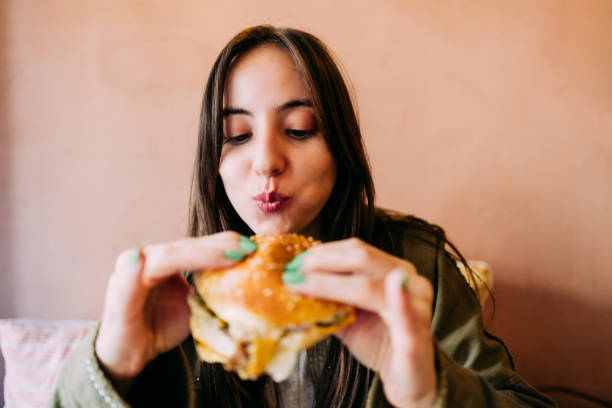 istock Woman eating beef burger 1468240117