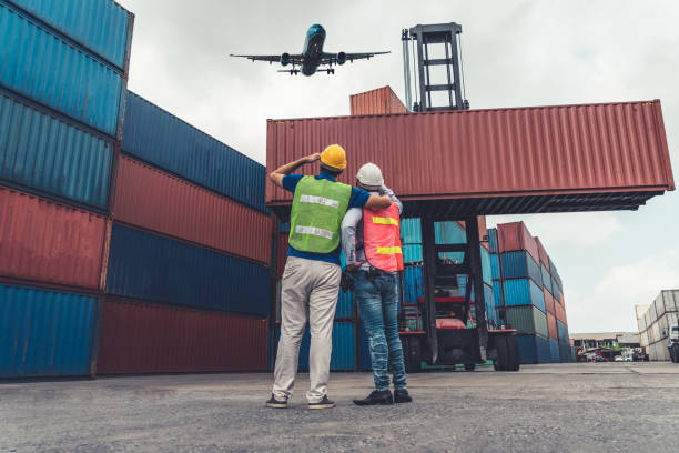 istock Industrial worker works with co-worker at overseas shipping container port . Logistics supply chain management and international goods export concept . 1468241456