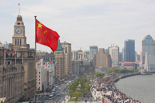The Bund in Shanghai, China, with Chinese flag View of the historic Shanghai Financial District and Huangpu Riverfront riverbank stock pictures, royalty-free photos & images