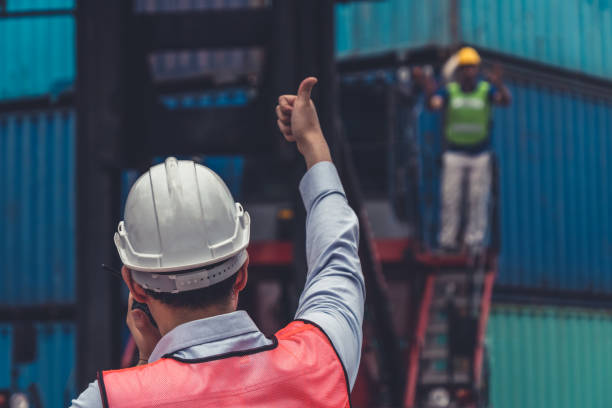 istock Industrial worker works with co-worker at overseas shipping container yard . Logistics supply chain management and international goods export concept . 1468243115
