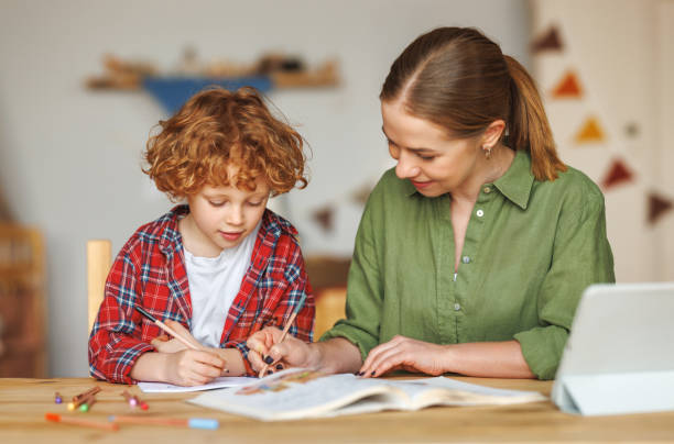 istock Cheerful mother doing homework with son at home 1468243266