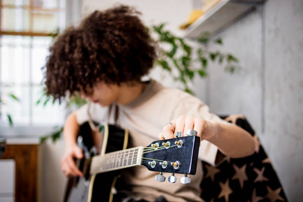 istock Boy tunes acoustic guitar 1468243280