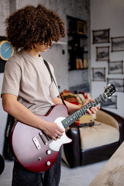 istock Young musician plays solo on electric guitar 1468243490