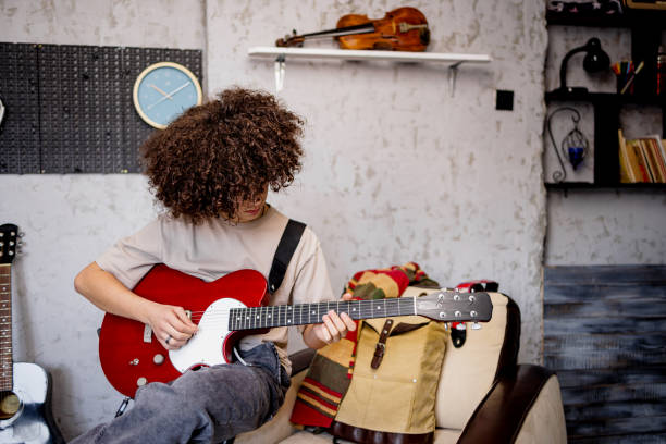 istock Young boy play electric guitar at home 1468243617