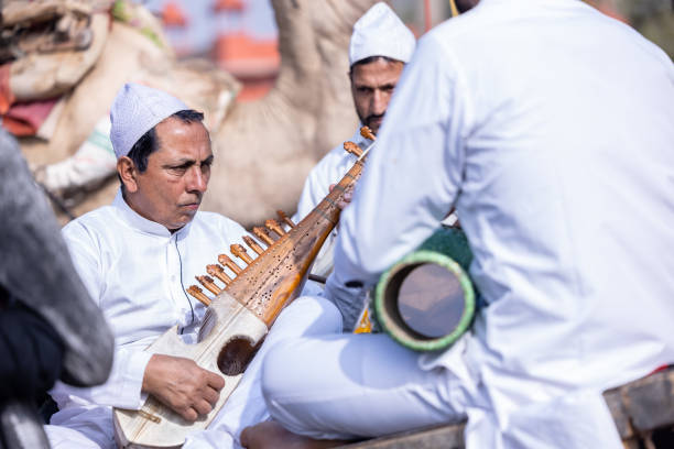 kaschmirischer männlicher künstler, der beim kamelfestival auftritt - men artist guitarist guitar stock-fotos und bilder