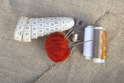 Centimeter tape, colored threads, thimble, red ball with needles.