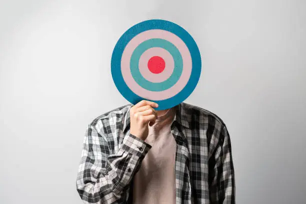 Photo of person holding target in front of head, internet sales targeting concept