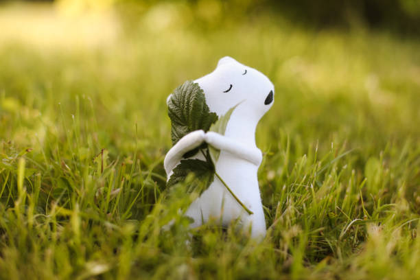 istock Eco-friendly cute handmade toy bear on grass at sunny summer day. 1468250355