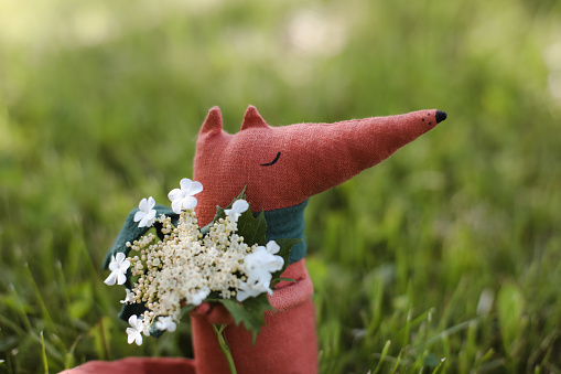 Eco-friendly cute handmade toy on grass at sunny summer day