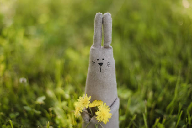 Eco-friendly cute handmade toy on grass at sunny summer day