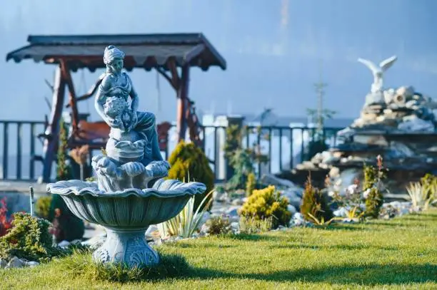 Photo of Fountain in the park garden. Water flows from the fountain.