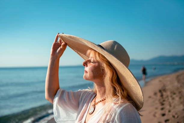 istock Woman Sunbathing her face under the sun hat 1468255109