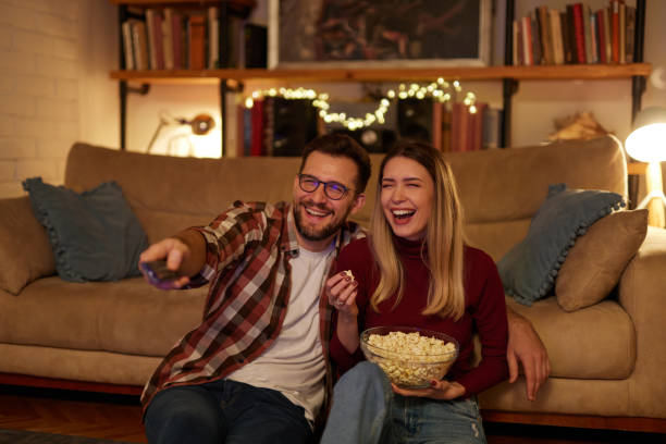 istock Young romantic couple watching TV at home 1468255815