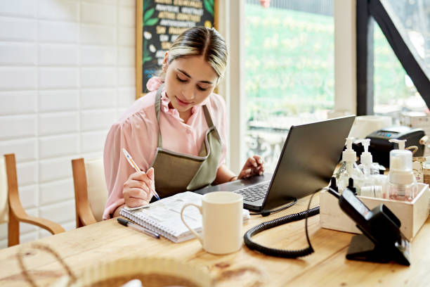 istock Saleswoman using laptop in small retail shop 1468256557