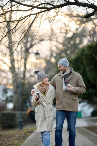istock A happy romantic couple with coffee walking outdoors in the park 1468257747