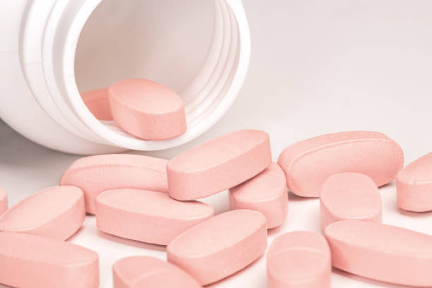 istock Spilled pink pills from open prescription medication plastic white bottle 1468258696