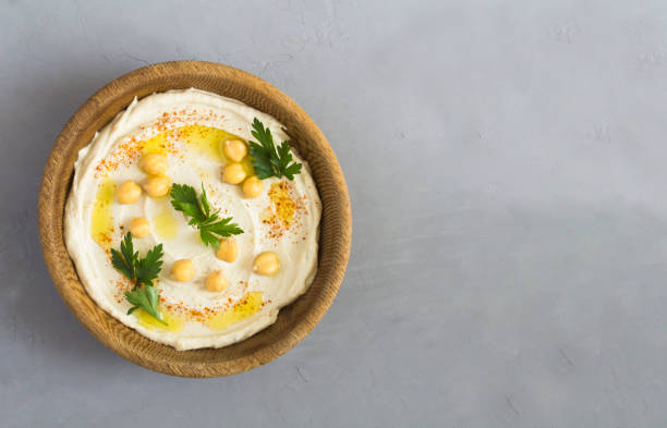 istock Hummus in the brown bowl on the gray cement background. Top view. Copy space. 1468263912