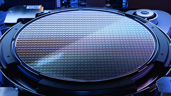 Front View of Silicon Wafer during Photolithography Process inside Complex Computer Chip Production Machine. Semiconductor Manufacturing at Fab or Foundry.