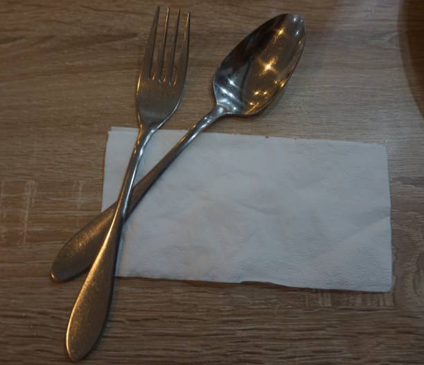 istock Fork with spoon and tissue paper on a wooden table in a cafe. 1468267125