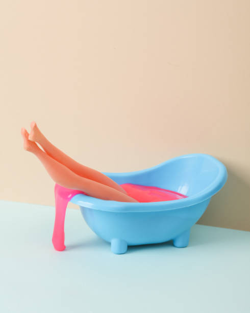 istock Creative layout, toy bathroom sink with doll legs and neon slime on two tone pastel background. Visual trend. 1468267621