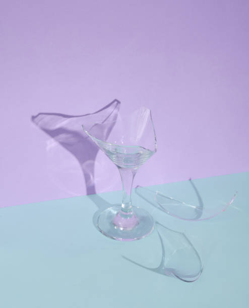 istock Creative layout with broken cocktail glass on two tone pastel background. Visual summer trend. Minimalistic aesthetic still life. Reflection, shadows 1468267661