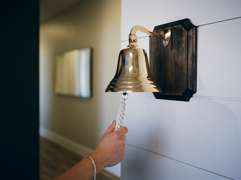 A large brass bell, hanging on a wall.