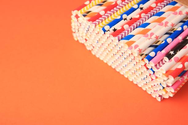 istock Many paper drinking straws on orange background. Space for text 1468273350