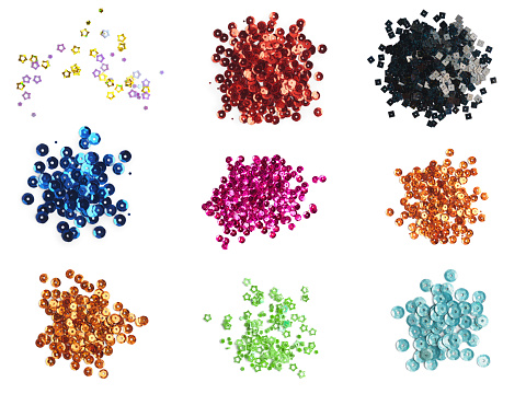 Set of different shiny sequins on white background, top view