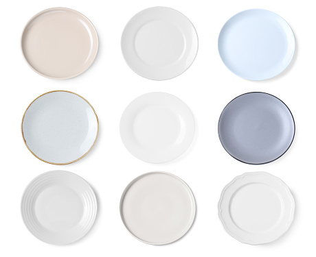 Set of different ceramic plates on white background, top view