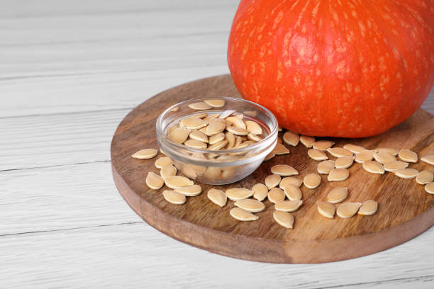 istock Fresh pumpkin and vegetable seeds on white wooden table, closeup 1468274745