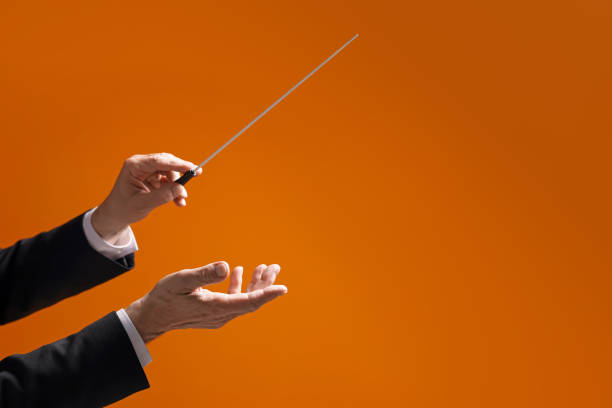 istock Professional conductor with baton on orange background, closeup. Space for text 1468276912