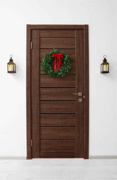 istock Beautiful Christmas wreath with red bow hanging on door 1468276977