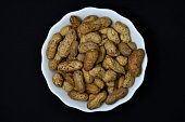 Groundnut. Unpeeled peanuts in a white plate. Peanuts in the peel.