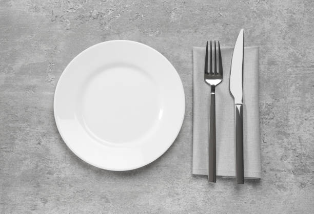 istock Clean plate and shiny silver cutlery on light grey table, flat lay 1468277712