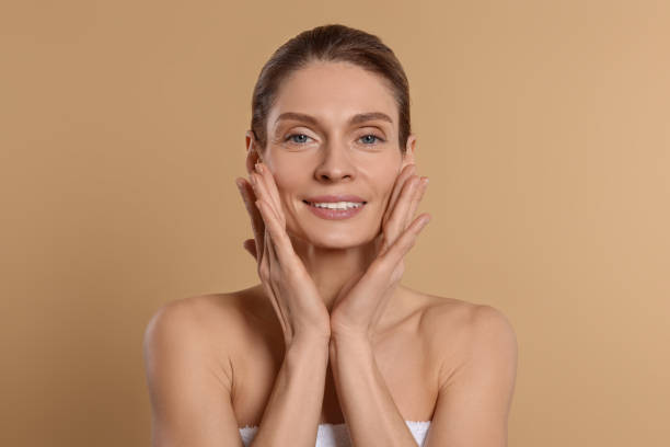 istock Woman massaging her face on beige background 1468277877