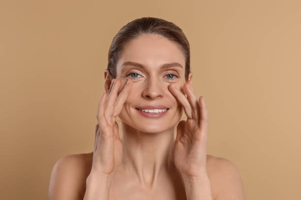 istock Woman massaging her face on beige background 1468278030