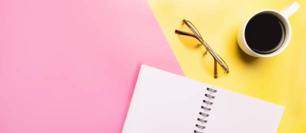 istock Minimal workspace with coffee cup and blank notepad on colored background. Top view. Flat lay. Copy space 1468279446