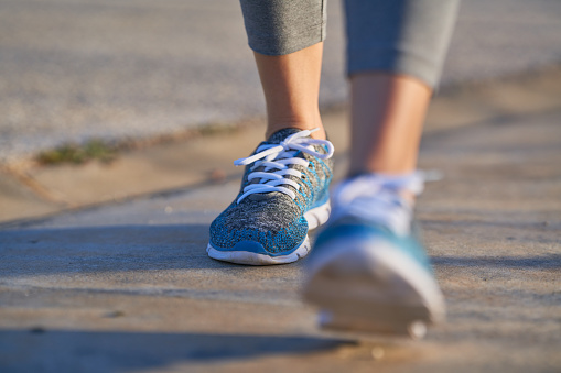 Vista de los pies de la mujer deportiva caminando, espacio de copia, vista desenfocada photo