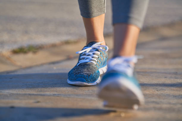 view of feet of sporty woman walking, copy space, unfocused view - levar algo imagens e fotografias de stock