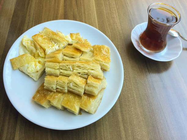 börek de comida turca em um prato com chá na mesa do café, fatias de börek em um prato com chá - 15839 - fotografias e filmes do acervo