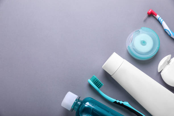 istock Flat lay composition with dental floss and different teeth care products on grey background. Space for text 1468283110