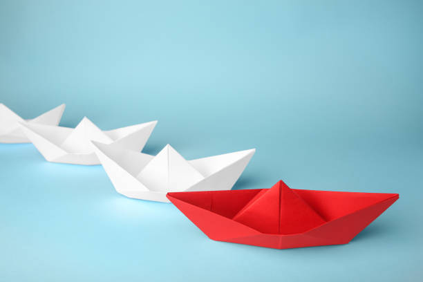 istock Red paper among others on light blue background. Leadership concept 1468283183