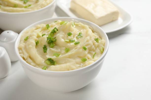 istock Bowls of delicious mashed potato with green onion on white table 1468283360