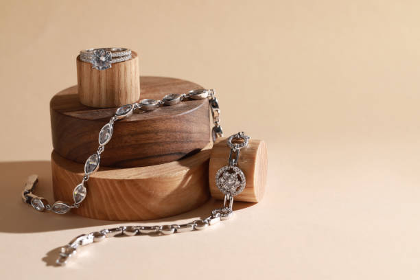 stilvolle präsentation von eleganten armbändern und ringen auf holzpodesten, platz für text. luxusschmuck - costume jewelry stock-fotos und bilder