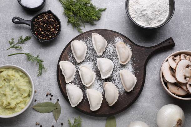 istock Raw dumplings (varenyky) and ingredients on grey table, flat lay 1468283899
