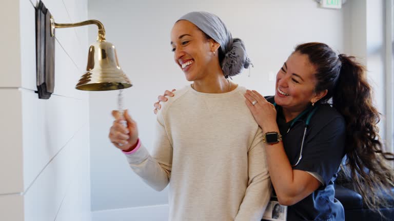 Adult Woman Chemotherapy Patient Finishing Treatment with a Ceremonial Bell Ring