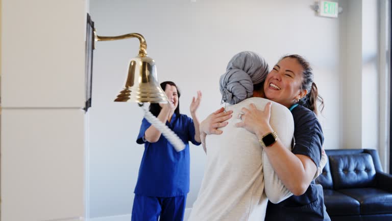 Adult Woman Chemotherapy Patient Finishing Treatment with a Ceremonial Bell Ring