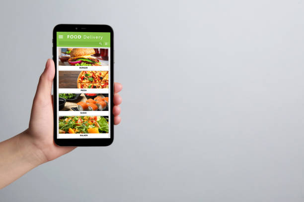istock Food delivery service. Woman choosing dish from menu on site using smartphone on light grey background, closeup and space for text 1468285798