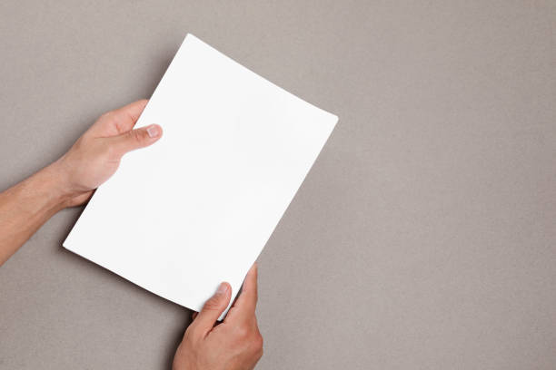 istock Man holding sheets of paper on grey background, closeup. Mockup for design 1468285914